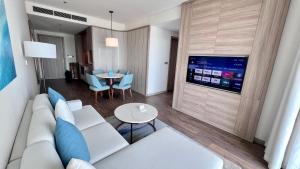 a living room with a white couch and a table at Executive Bay View A La Carte Hạ Long in Ha Long