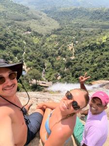 two men and a woman sitting on top of a mountain at Thomasha Homestay Wellawaya in Wellawaya