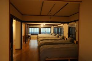 a row of beds lined up in a row in a room at TomaReno Beppu-Kitahama in Beppu