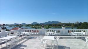 a patio with white tables and chairs on a balcony at Skyview Hotel in Ban Donsôm Tai