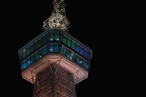 a tall building with lights on it at night at TomaReno Beppu-Kitahama in Beppu