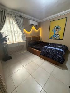 ein Schlafzimmer mit einem Bett und einem Fenster in der Unterkunft Royal Max in Ikeja