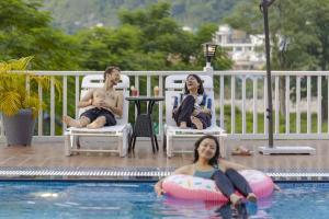 a group of people sitting in chairs by a swimming pool at PACK Rishikesh, Mohanchatti in Rishīkesh