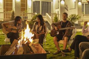 a group of people sitting around a firepit playing guitars at PACK Rishikesh, Mohanchatti in Rishīkesh