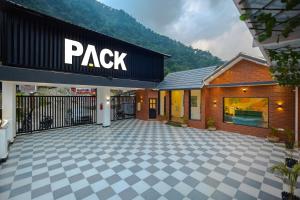 a building with a parking lot in front of a store at PACK Rishikesh, Mohanchatti in Rishīkesh