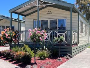 a small house with flowers in front of it at Paynesville Holiday Park in Paynesville