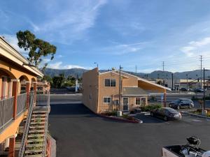 a parking lot next to a building with mountains in the background at Desert Inn Motel in Corona