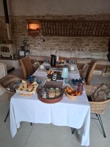 a table with food and baskets of food on it at Chambres d'hotes "Chez Marchio" in Crottet
