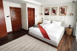 a bedroom with a white bed with a red tie on it at Mali Villa 57 in Patong Beach +61 photos