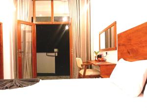 a hotel room with a bed and a desk and a bedroom at Aureva Guest in Weligama +16 photos
