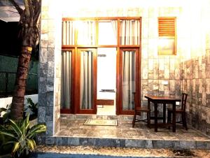 a door to a house with a wooden table and a table sidx sidx at Aureva Guest in Weligama