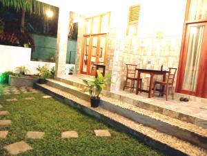 a courtyard of a house with a table and chairs at Aureva Guest in Weligama