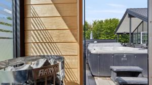 a bathroom with a bath tub next to a house at Villavilla 520 - Mommark, Sydjylland in Sarup