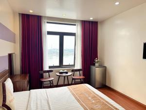 a hotel room with a bed and a table with chairs at New Hotel Phủ Lý in Trượng Trâu