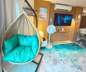 a room with a rattan swing with a couch at Condotel in Tambuli Seaside Studio - F21K in Maribago