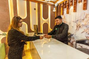 a man and a woman shaking hands at a table at Treebo Premium Landmark Prayagraj in Prayagraj