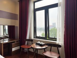 a hotel room with a table and chairs and a window at New Hotel Phủ Lý in Trượng Trâu