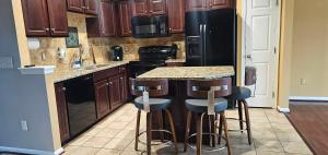 a kitchen with a black refrigerator and bar stools at Townhome in Ranson, WV in Ranson