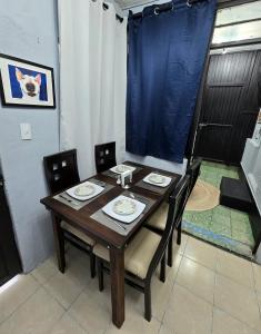 a dining room table with chairs and a blue curtain at Departamento Completo en el Centro de Monterrey in Monterrey