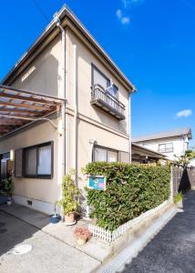 a house with a hedge in front of it at ゲストハウス あぽわん 貸切宿無料駐車場 in Mitoyo