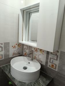 a bathroom with a white sink and a mirror at Motel NHÀ SAM in áº¤p VÄ©nh ÃÃ´ng
