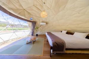 a bedroom in a tent with a bed and a table at Private Glamping NAGOMI CAMP in Nasushiobara