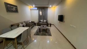 a living room with a couch and a table at شقق اطلالة اجاء المخدومة in Hail