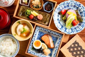 a table with plates of food and bowls of rice at Bessou Konjakuan in Yufu