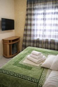 a pile of towels sitting on top of a bed at ApartHotel EURO in Cahul