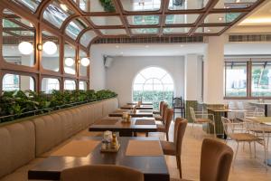 a restaurant with tables and chairs and windows at Areca Lodge in Pattaya