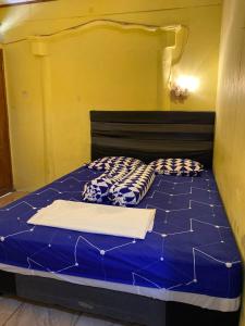 a bed with two pillows on it in a room at Hatiku Guesthouse in Bunaken +2 photos