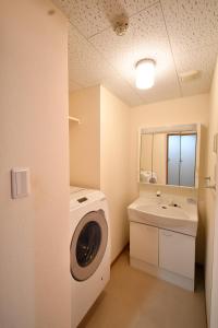a bathroom with a washing machine and a sink at ウエストワン サウス105Kawasemi in Hitoyoshi