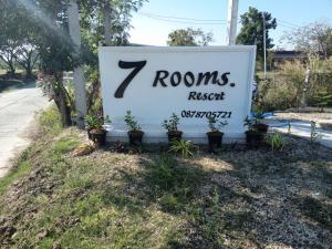 a sign that reads rooms revision next to plants at 7 Rooms resort in Ban Tamyae