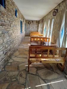 a room with benches and a stone wall at Nandi Roop Homestay in Panuānaula
