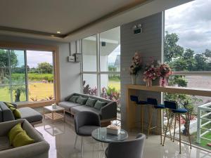 a living room with couches and a table and chairs at เพาะสุข กู๊ดดรีม in Ban Wang Hu Kwang
