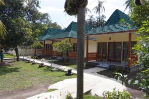 a house with a palm tree in front of it at Salili Resort in Gili Islands