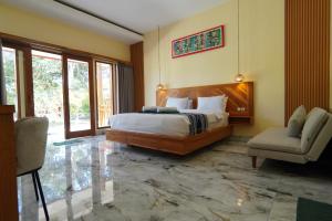 a bedroom with a large bed and a chair at Salili Resort in Gili Islands +20 photos