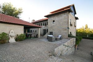 a brick building with a patio and a building at Casa Rural Da Costeira in Cinfães