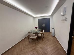 a dining room with a glass table and chairs at Ujang Guest House in Batu Kikir