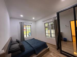 a bedroom with a bed and a mirror at Ujang Guest House in Batu Kikir