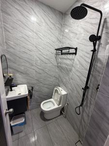 a small bathroom with a toilet and a shower at Ujang Guest House in Batu Kikir