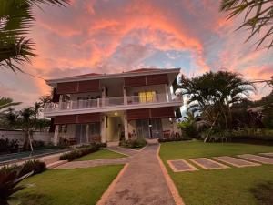 a large house with a sunset in the background at Villa Nah Amed in Amed