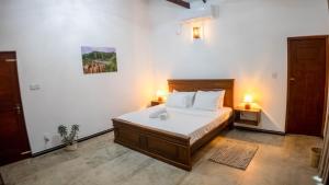 a bedroom with a large bed with two lamps on it at Dana Villa in Bentota