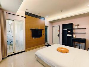 a bedroom with a bed and a tv on a wall at Kinmen Harved B&B in Jinhu