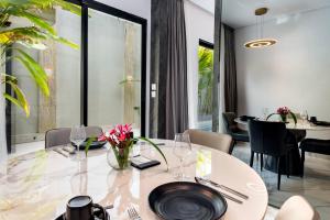 a dining room with a white table and chairs at Anoya Boutique Villa in Kerobokan