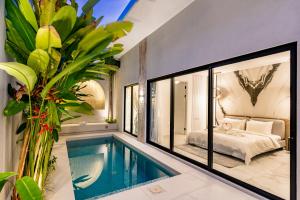 a house with a swimming pool and a bedroom at Anoya Boutique Villa in Kerobokan
