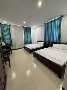 a room with two beds and a desk in it at Thi Long Phụng Hotel in Phú Quốc +31 photos