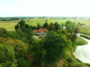 a house on a hill next to a river at Dwór Osmolice in Białki Dolne