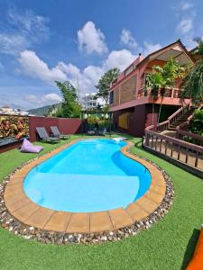 a large swimming pool with a wooden path around it at The Cozy House in Karon Beach