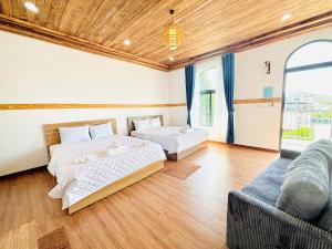 a bedroom with two beds and a couch at Homestay Mr Hồng Vĩnh Hy in Ninh Hải